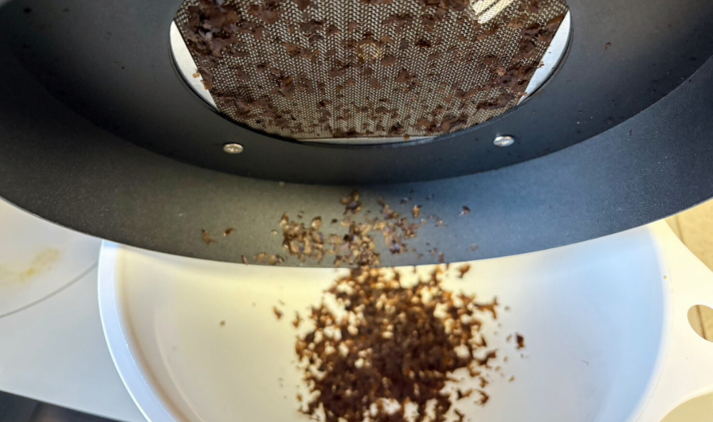 コーヒークーラーに溜まったチャフをボウルに落としている